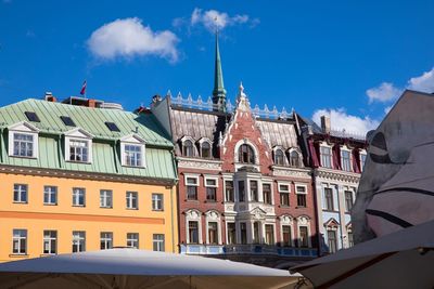 Low angle view of buildings in town against sky