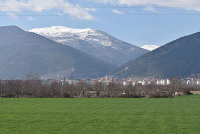 Scenic view of field and mountains against sky