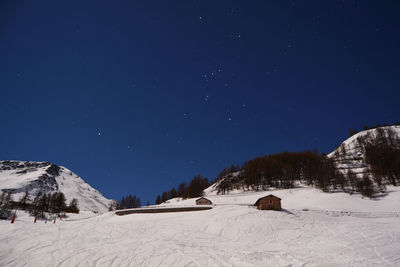 Scenic view of snow covered mountains against blue sky