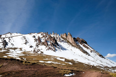 Scenic view of snowcapped mountains against blue sky