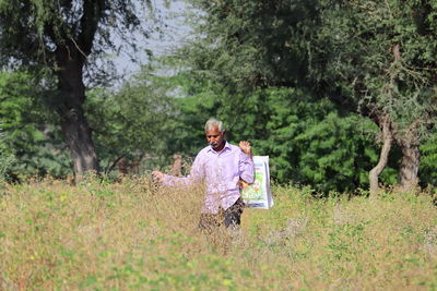 Man standing on field in forest