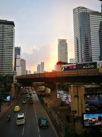 Traffic on city street amidst buildings against sky