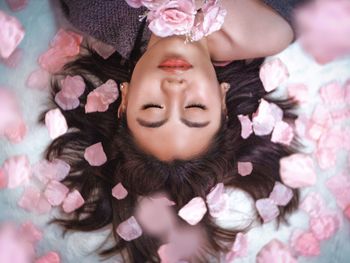 Portrait of woman lying on pink flowers