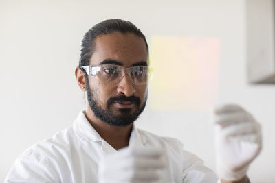 Young man scientist with lab coat checking a sample