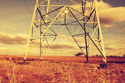 Electricity pylon on field against sky