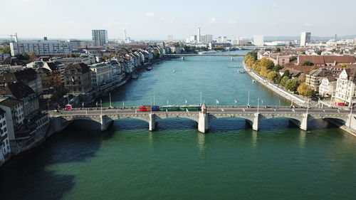 Bridge over river in city against sky