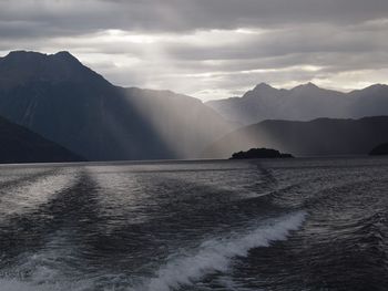 Scenic view of sea and mountains against sky