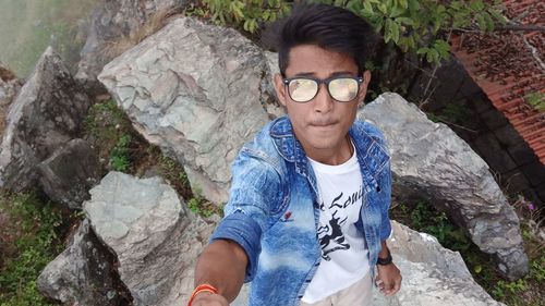 Portrait of young man standing on rock