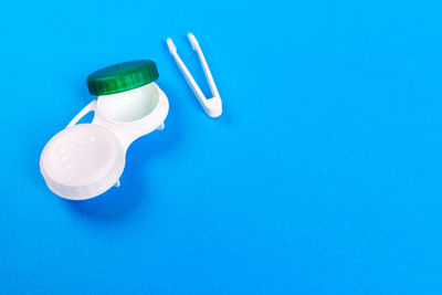 High angle view of drinking glasses against blue background