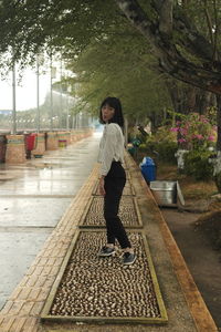 Full length of woman with umbrella walking on plants