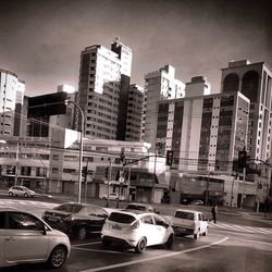 Cars on road in city against sky
