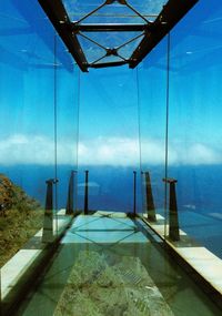 Swimming pool by sea against blue sky