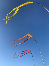 Low angle view of flags against blue sky