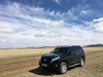 Vintage car on landscape against sky