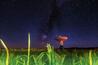 Low angle view of stars on field against sky at night