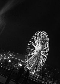 Low angle view of illuminated ferris wheel against sky at night