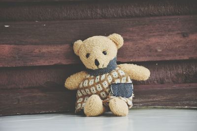 Teddy bear against wall