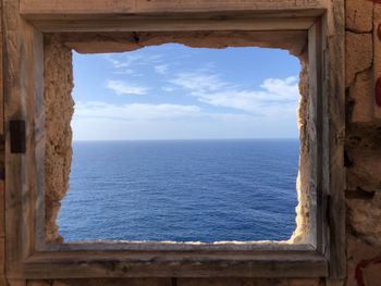 Scenic view of sea against sky seen through window