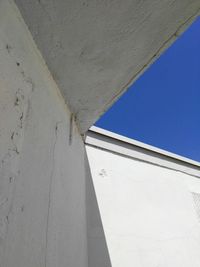 Low angle view of white wall against blue sky