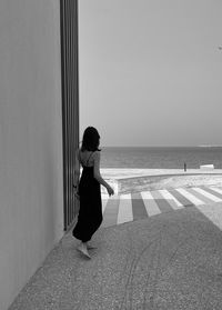 Rear view of woman standing at beach