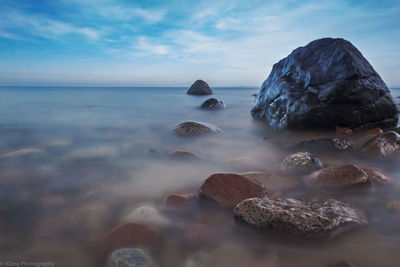 Close-up of rocks on shore against sky