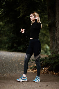 Full length of young woman standing outdoors with a skipping rope