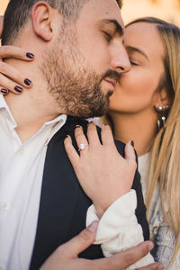 Young couple kissing friends on bridge