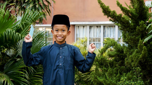 Portrait of smiling boy standing against plants