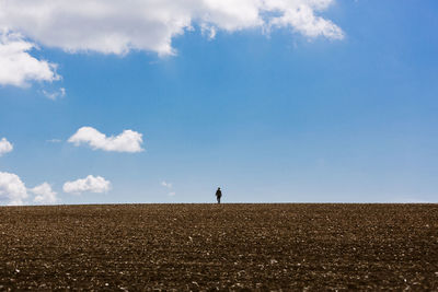 Man standing on field against sky