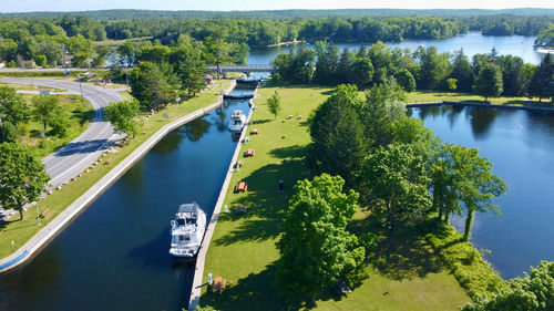 High angle view of boats on a canal amidst trees against sky