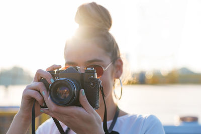 Close-up of woman photographing against clear sky