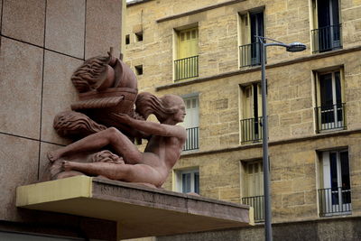 Low angle view of statue against building in city