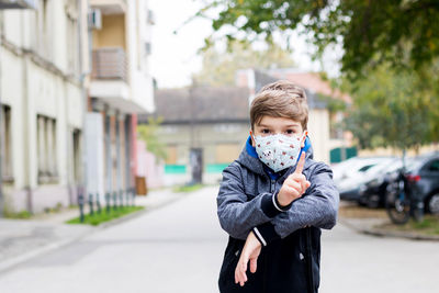 Portrait of boy holding camera in city