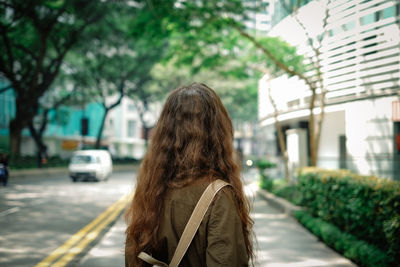 Woman standing on road in city