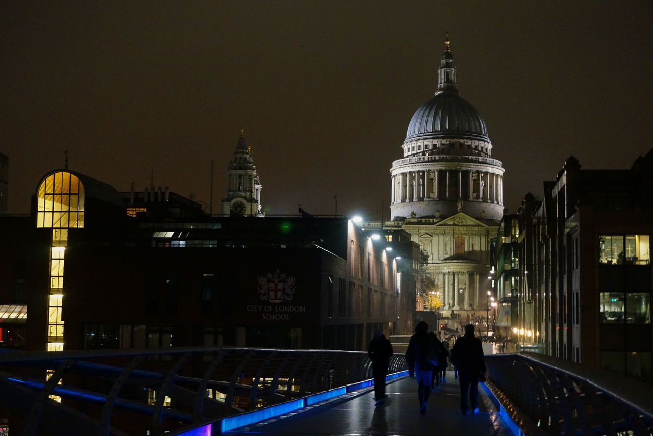 PEOPLE IN ILLUMINATED CATHEDRAL AGAINST SKY