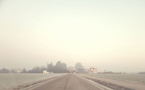 Empty road against sky in foggy weather