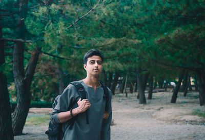 Portrait of young man standing in forest