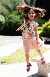 Portrait of happy girl smiling on footpath