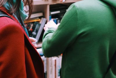 Midsection of man and woman standing at library