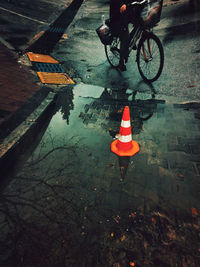 Low section of person riding bicycle on puddle during rainy season