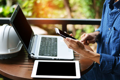 Low angle view of man using mobile phone on table