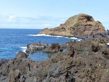 Scenic view of sea and rocks against sky