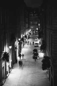 High angle view of people walking at illuminated street at night