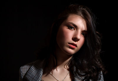 Portrait of a beautiful young woman over black background