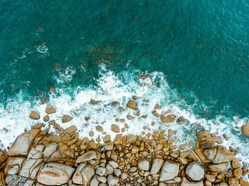 High angle view of stone wall by sea