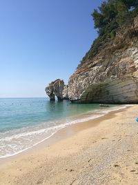 Scenic view of beach against clear blue sky
