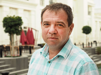 Close-up portrait of mature man standing in city