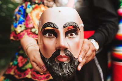 Midsection of woman holding mask