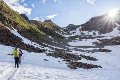 Rear view of man walking on snow covered mountain