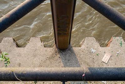 Low section of shoes on railing by river